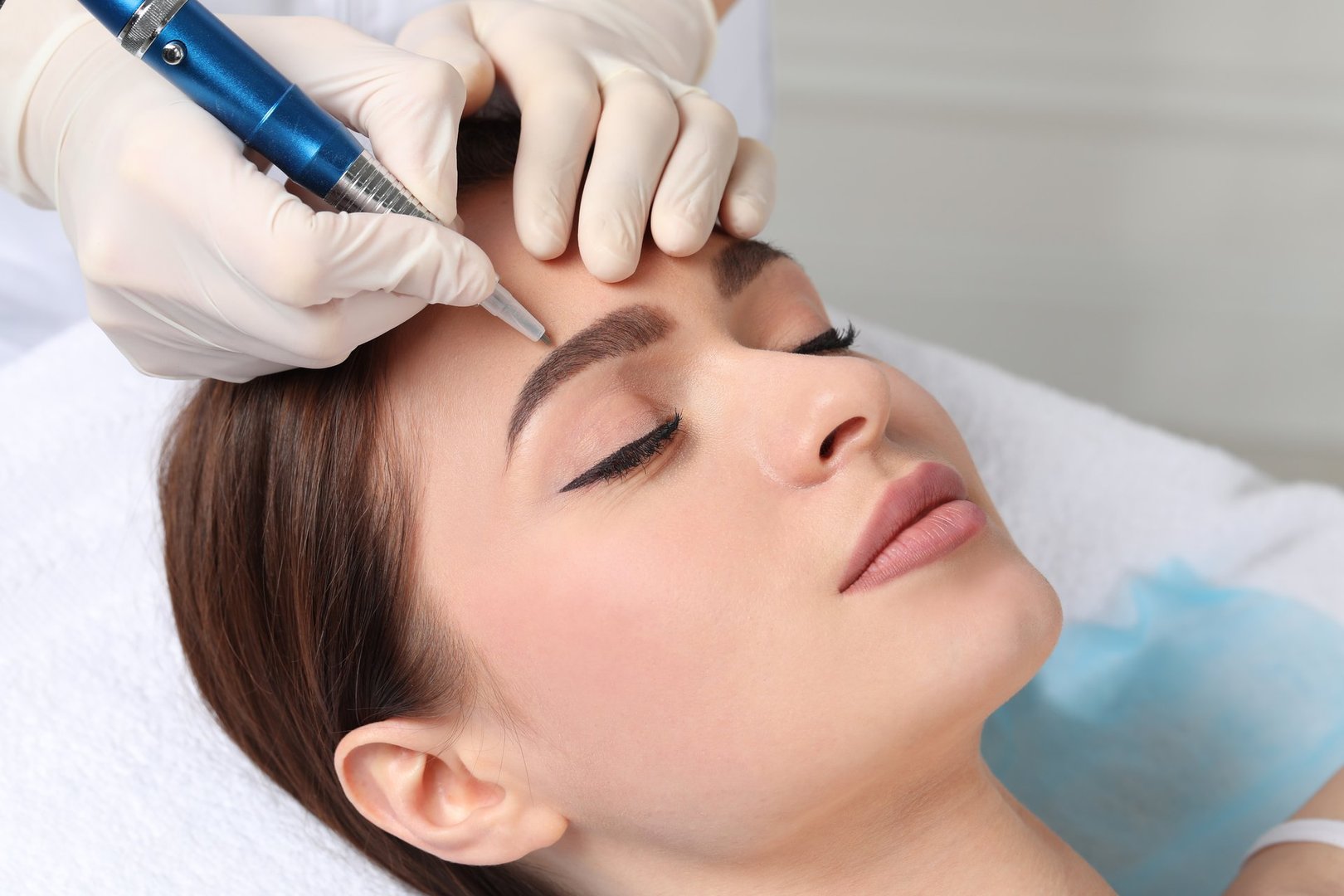 Woman receiving eyebrow microblading treatment